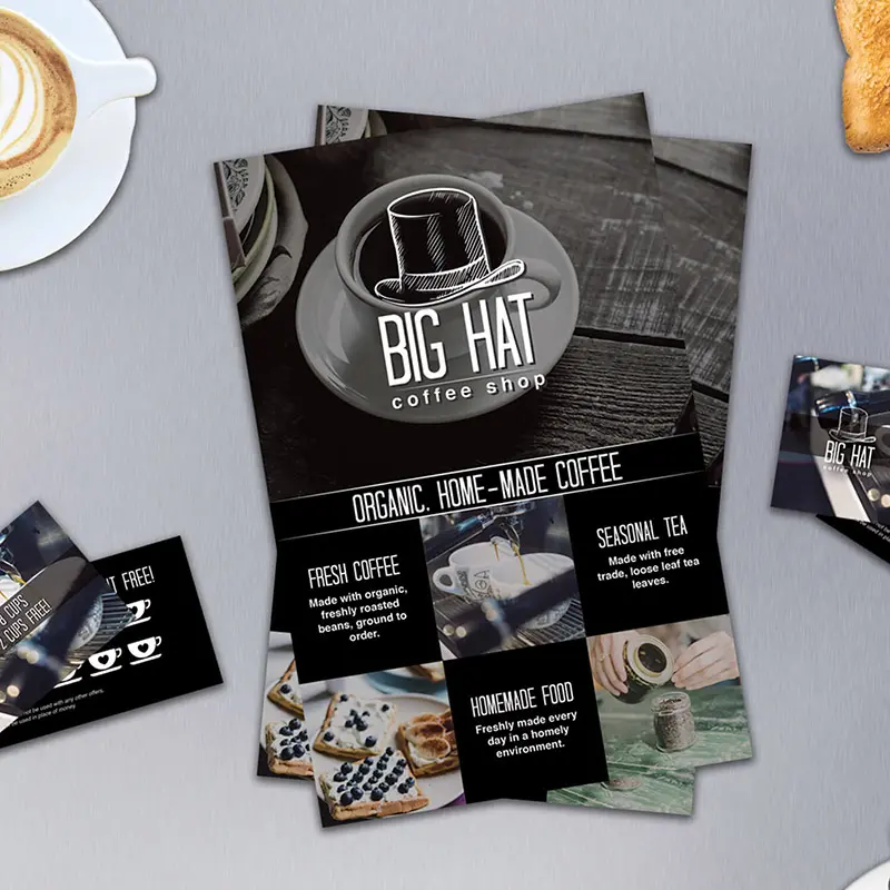 big hat coffee shop flyers and punch cards on a table with coffee and toast